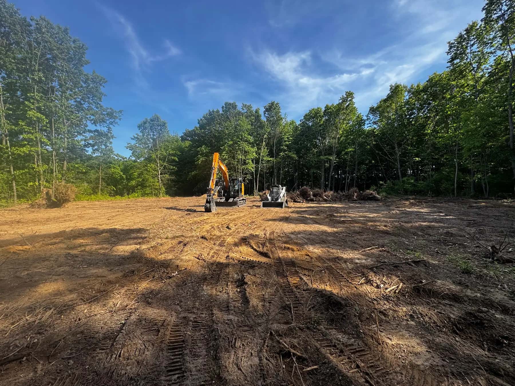 Excavator on a freshly cleared and rough-graded building site