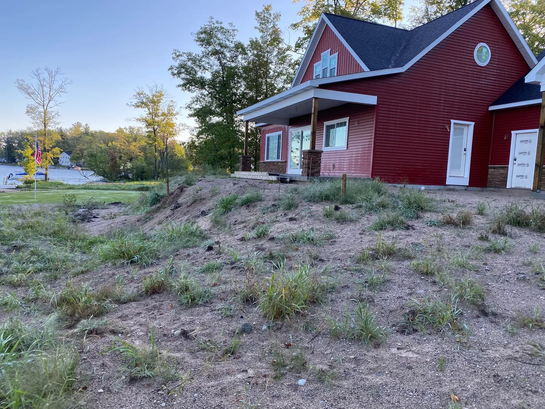 Yard graded and smoothed behind a red house after excavation