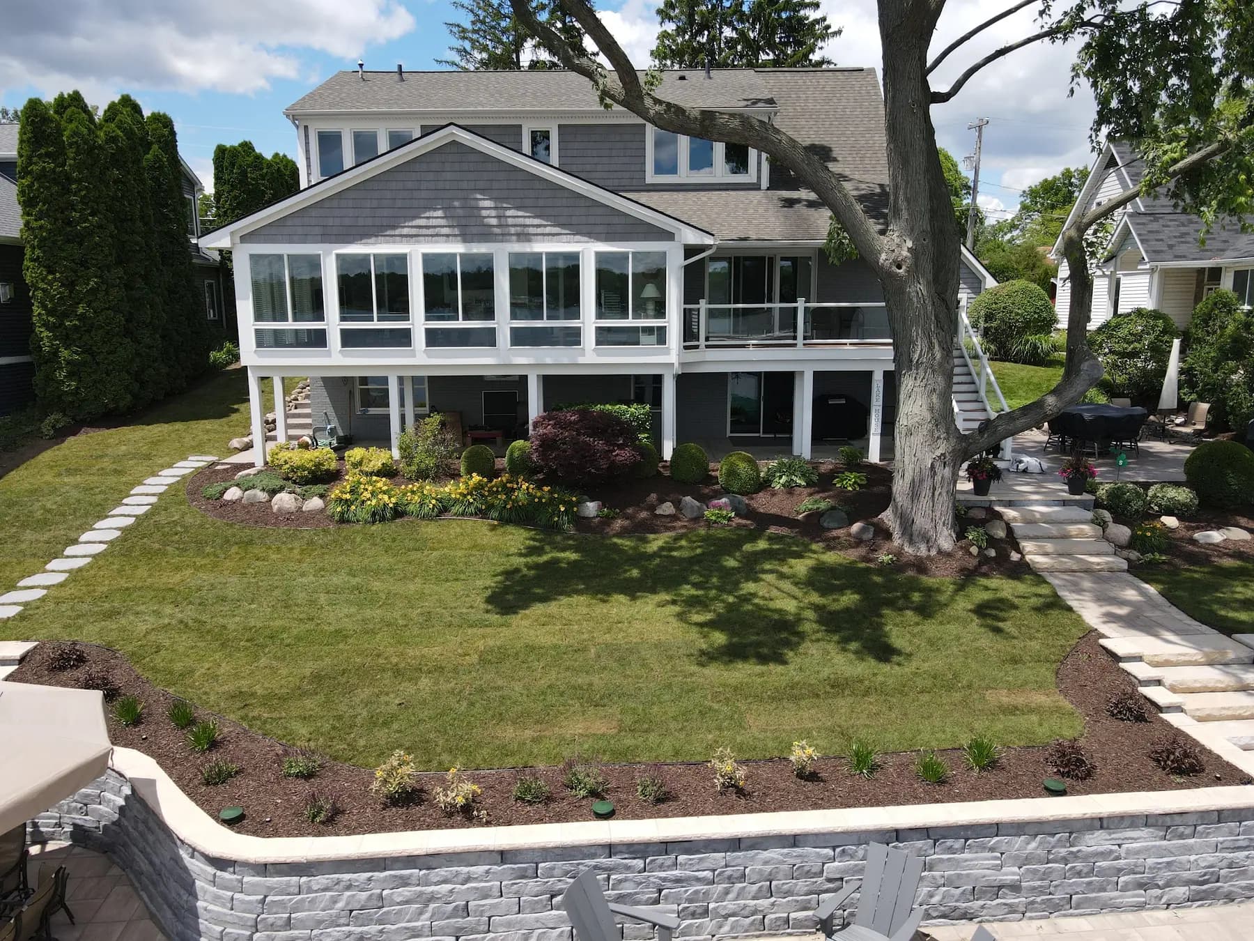 Stone steps and retaining walls leading down to a lake house