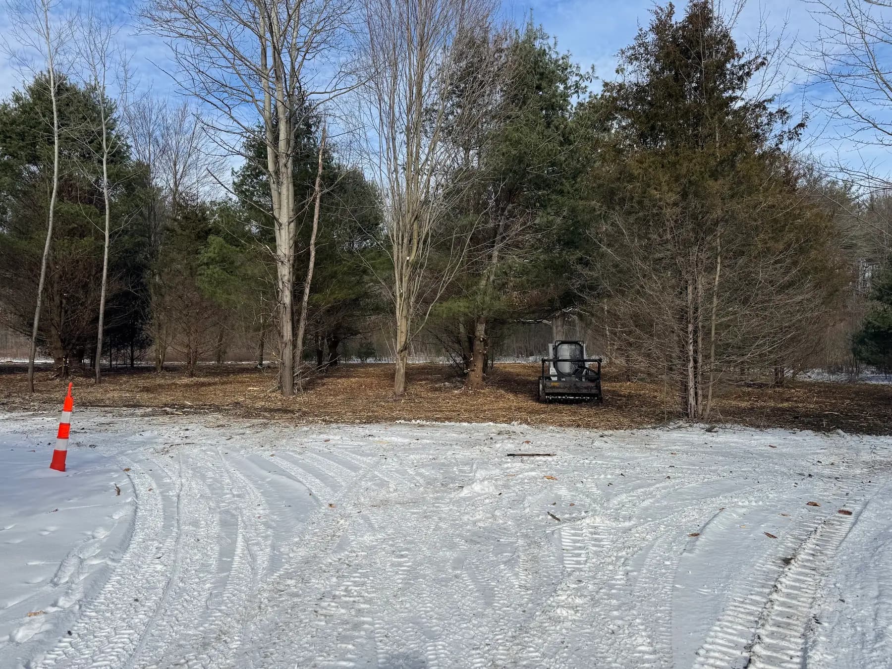 Cleared residential lot with the track loader working in light snow